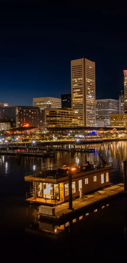 Baltimore skyline and a FLOHOM houseboat at night